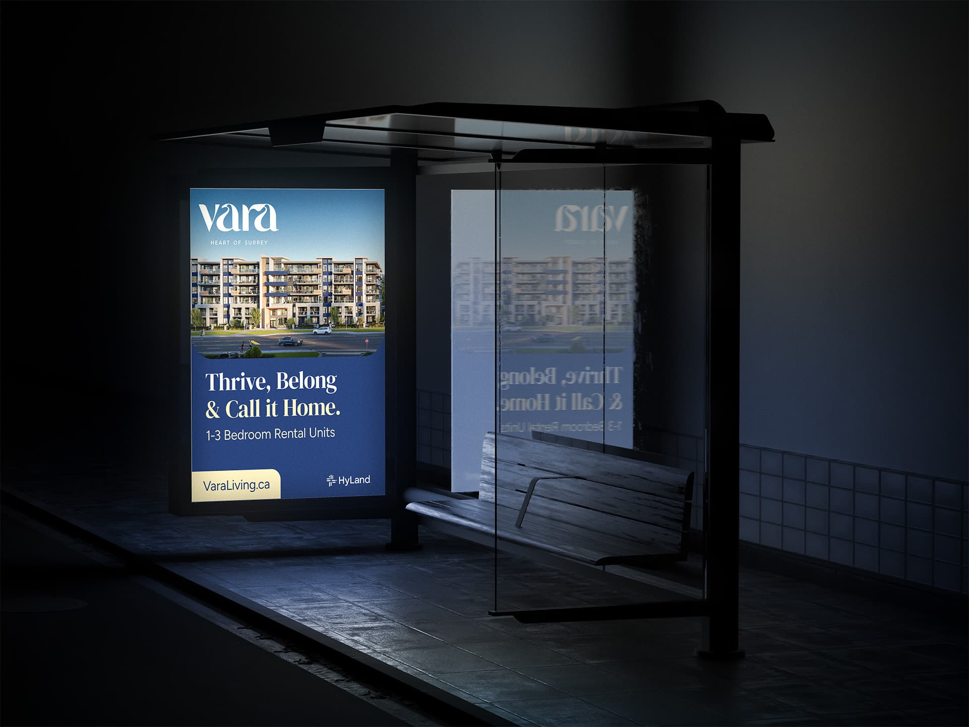 Backlit Vara bus shelter ad at night with a building rendering and the headline 'Thrive, Belong & Call it Home.'
