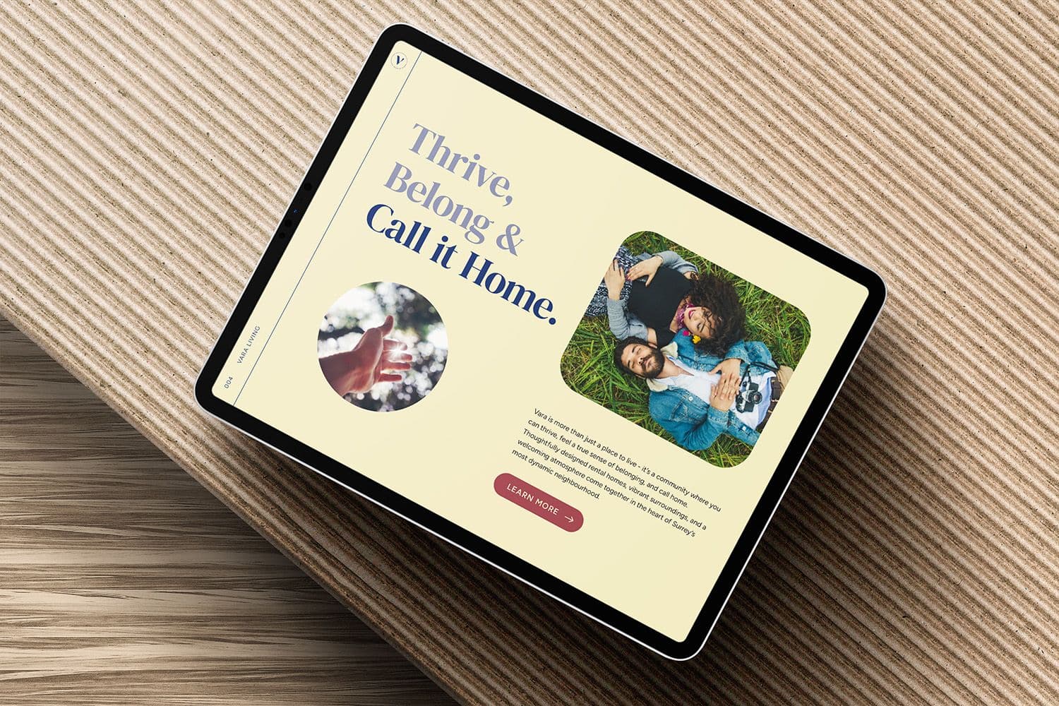 Tablet showing a Vara rental website page headlined 'Thrive, Belong & Call it Home.' on a ribbed surface