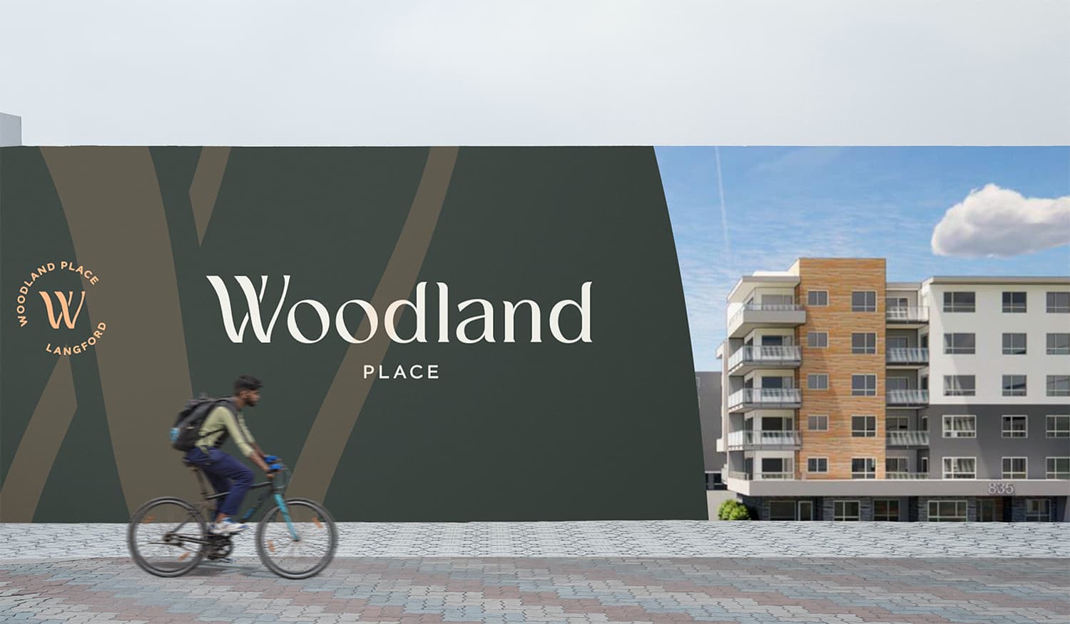 Woodland Place construction hoarding with the logo and a building rendering as a cyclist rides past