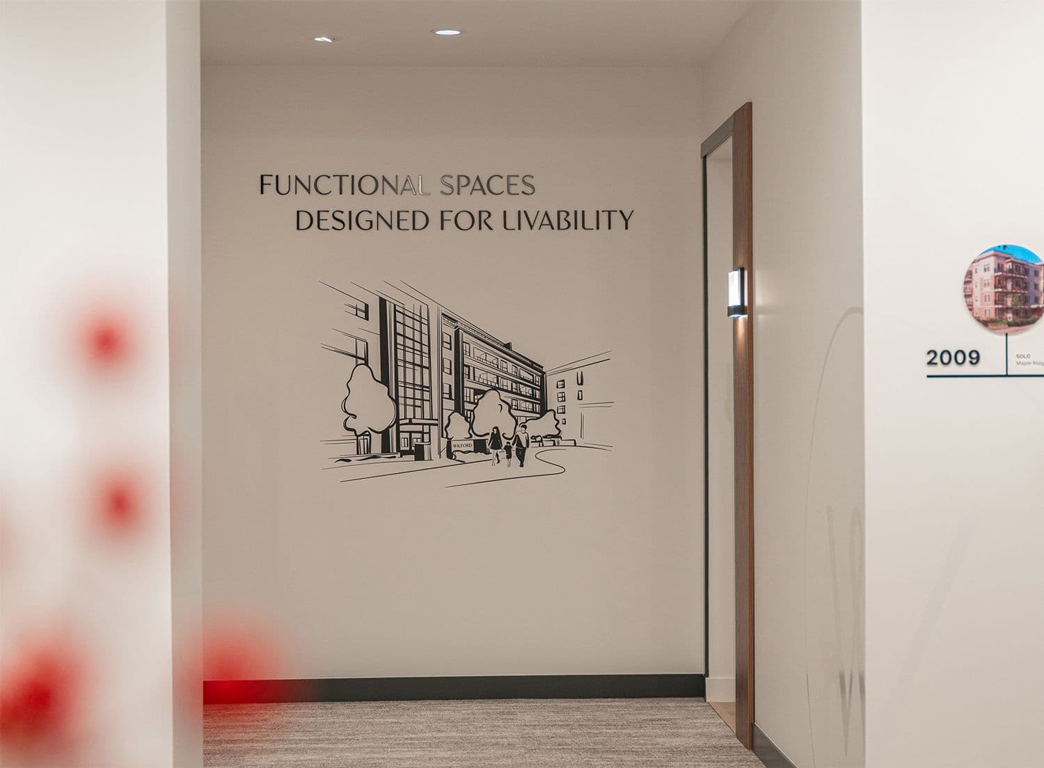Wilford interior wall graphic reading 'Functional Spaces Designed for Livability' with a line drawing of the building